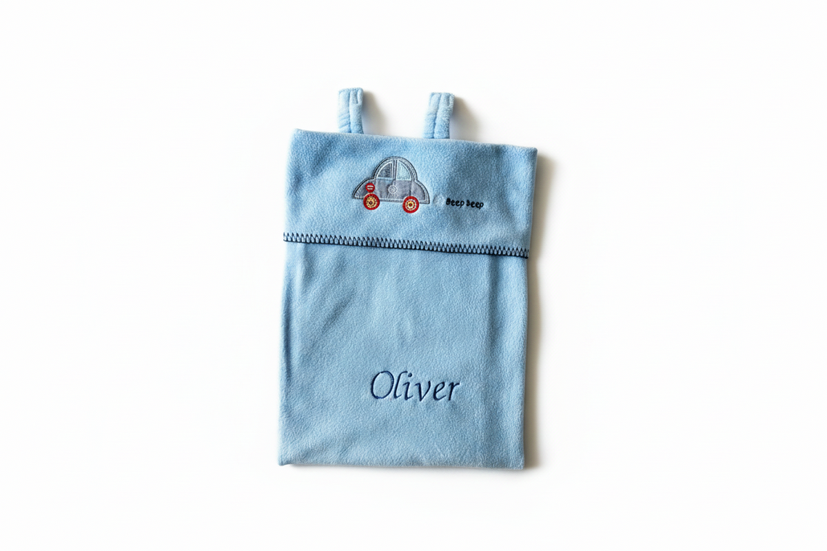 Personalised blue car seat blanket folded to show car embroidery and Oliver name, on a white background